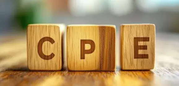 Wooden blocks spelling “CPE” on a tabletop, representing continuing professional education.