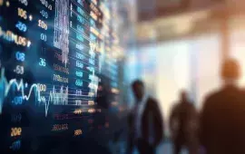 Financial data displayed on a screen with business professionals in the background.